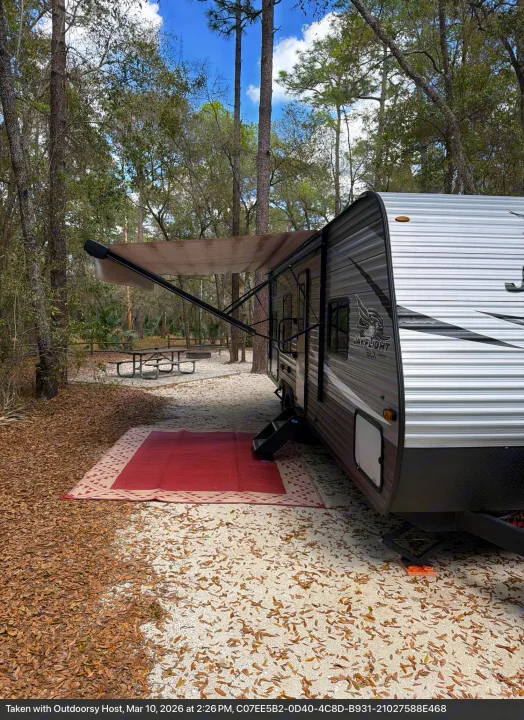 Jay Flight rv rental: a cozy campsite setup with extended awning, outdoor mat, picnic table & fire pit.. Jayco Jay Flight SLX 2021