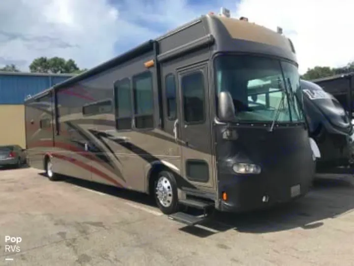 Spacious brown/tan motorhome, ideal for an RV rental, with a black front mask, parked outdoors on a sunny day.. Gulf Stream Tour Master 2007