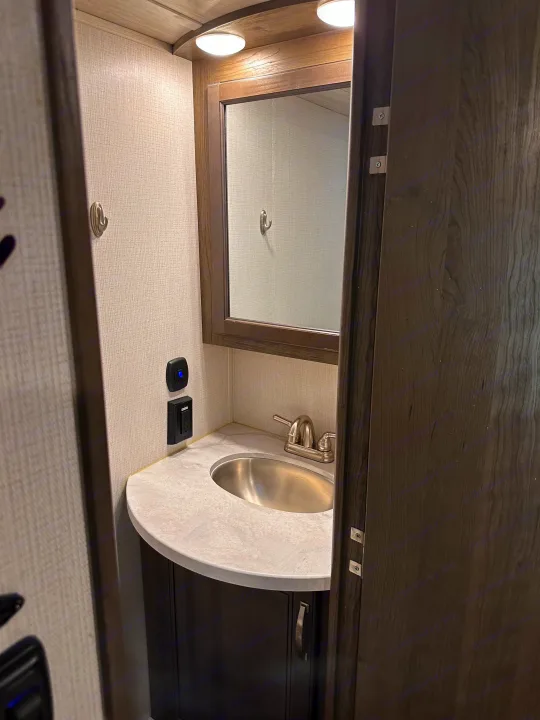 RV rental bathroom vanity: modern design, stainless steel sink, mirror, overhead lights, and storage below.. Keystone RV Cougar 2022