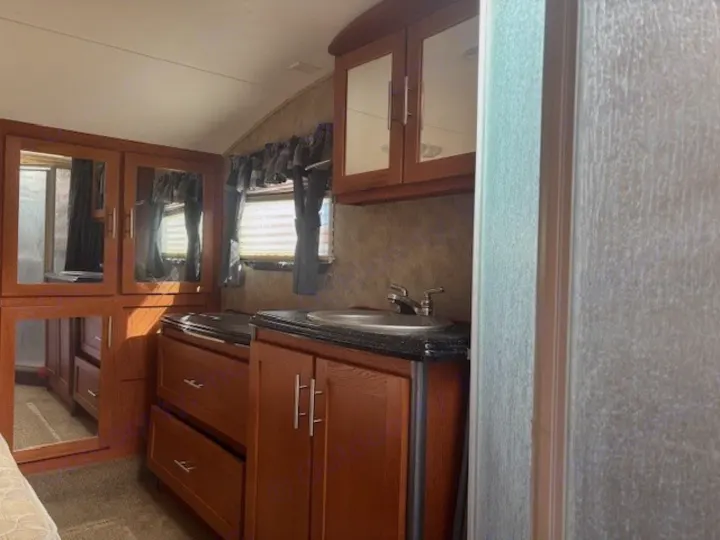 View inside an rv rental, showing a compact bathroom vanity with sink, mirrored cabinets, and storage drawers.. Keystone RV Fuzion Toy Hauler 2009