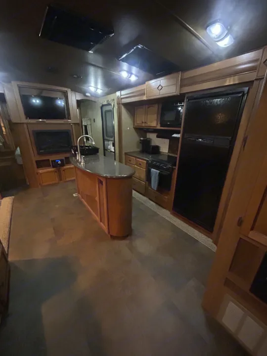 RV rental: Spacious interior with a full kitchen, island, and living area, featuring warm wood finishes.. Crossroads RV Sunset Trail Reserve 2014