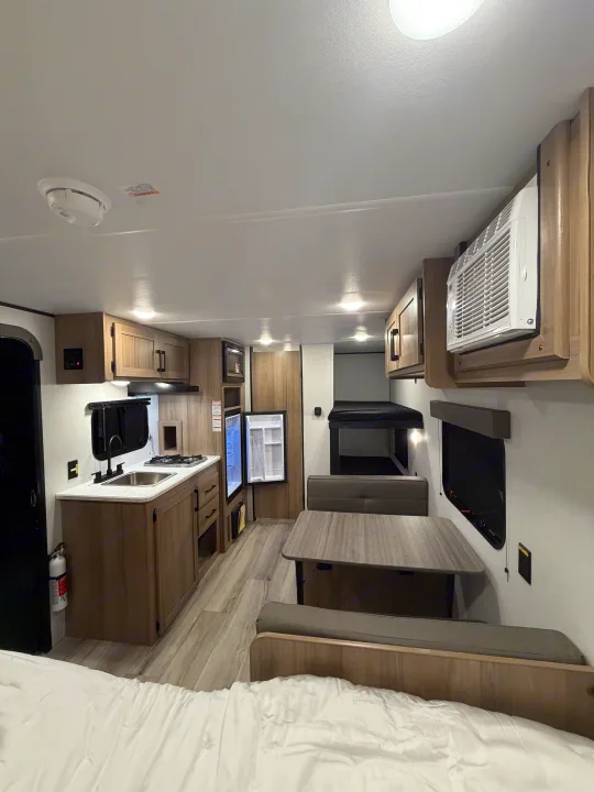 Spacious modern RV rental interior featuring kitchen, dining, bunk beds, and comfortable sleeping area.. Coleman 17B 2026