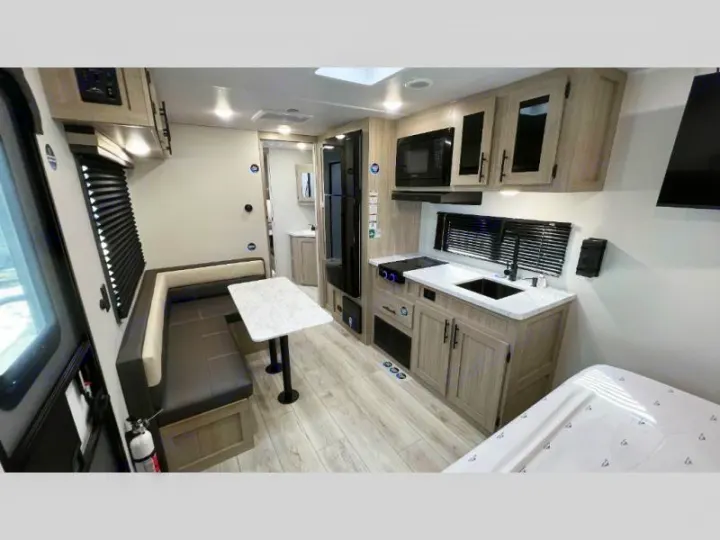 Modern rv rental interior with kitchen, dining booth, and bed area. Enjoy comfort on your next adventure.. Della Terra 250QB 2026