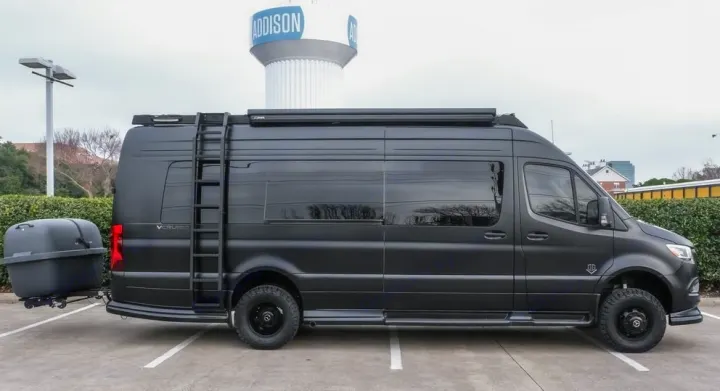 This matte black adventure RV rental, a custom Sprinter van with off-road tires and a rear cargo trailer, awaits you.. OGV EXPLORE VSPORT 100BA 2024