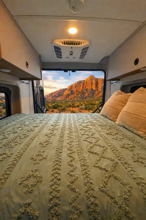 Cozy RV rental bedroom with a stunning mountain landscape view, offering a perfect escape for nature and van life adventures.. Winnebago Solis 2026