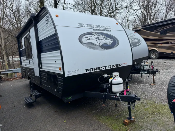 White and black Forest River Cherokee Wolf Pup travel trailer, an ideal rv rental, parked with propane tanks and hitch.. Forest River WOLF PUP 17LP 2026
