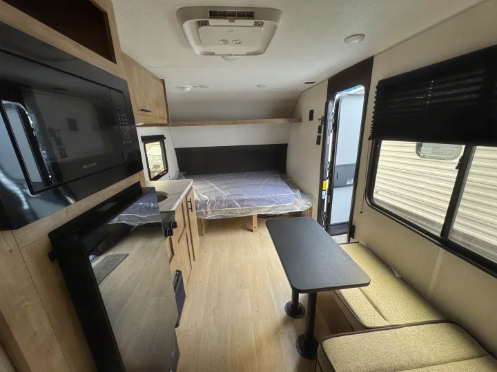 This RV rental interior showcases a kitchenette, rear bed, dinette, and wood-look floor, ready for your adventures.. Forest River WOLF PUP 17LP 2026