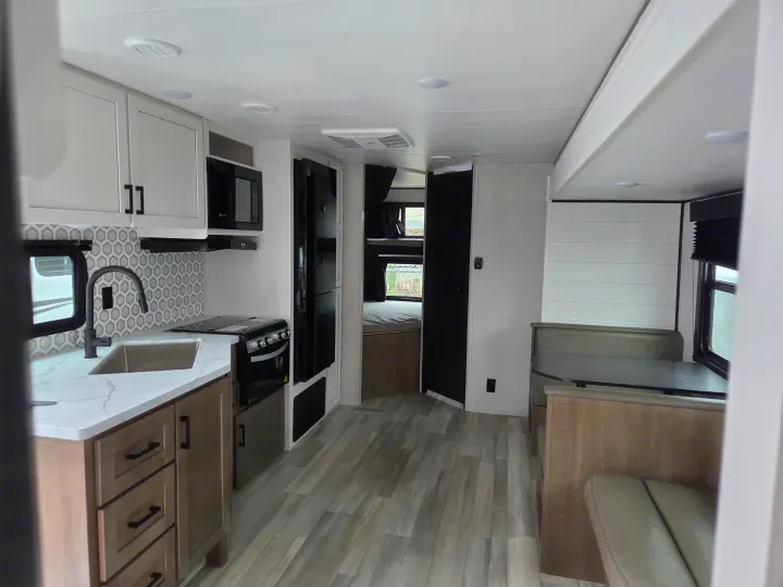 Modern RV rental interior with full kitchen, dinette, and bunk beds. Perfect for family adventures!. Open Range Conventional 26BHS Travel Trailer 2025