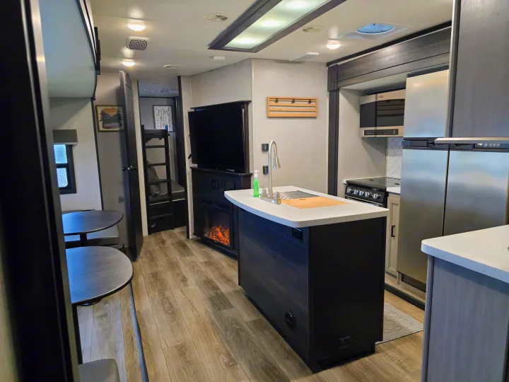 RV rental: Bright interior featuring a modern kitchen island, dining nook, TV, and bunk beds.. Highland Ridge RV Mesa Ridge 2021
