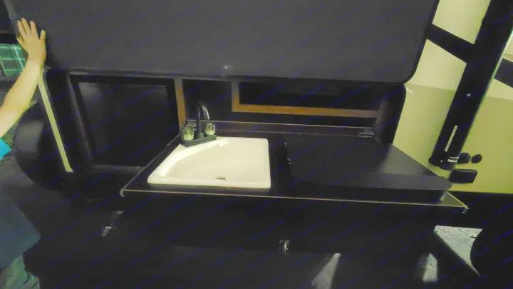 This RV rental's compact kitchen features a white sink, faucet, and counter, with an open overhead cabinet, providing essential amenities.. Cruiser RV MPG Ultra Lite 2017
