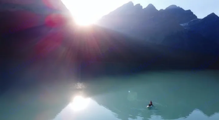 Bright sunbeams on a calm lake, a paddleboarder, and majestic mountains. Plan your escape with an RV rental.. Toyota Tacoma 2020