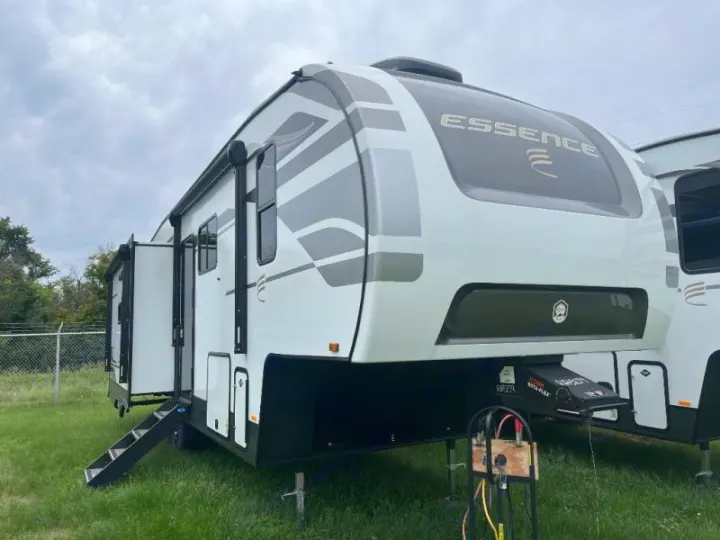 Spacious Essence fifth-wheel rv rental parked on grass, ready for adventure with open door and steps.. Cruiser RV Essence 2025