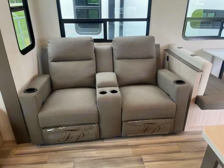 Enjoy plush recliner seating with multiple cup holders in this cozy RV rental interior, offering comfort and scenic views.. Cruiser RV Essence 2025