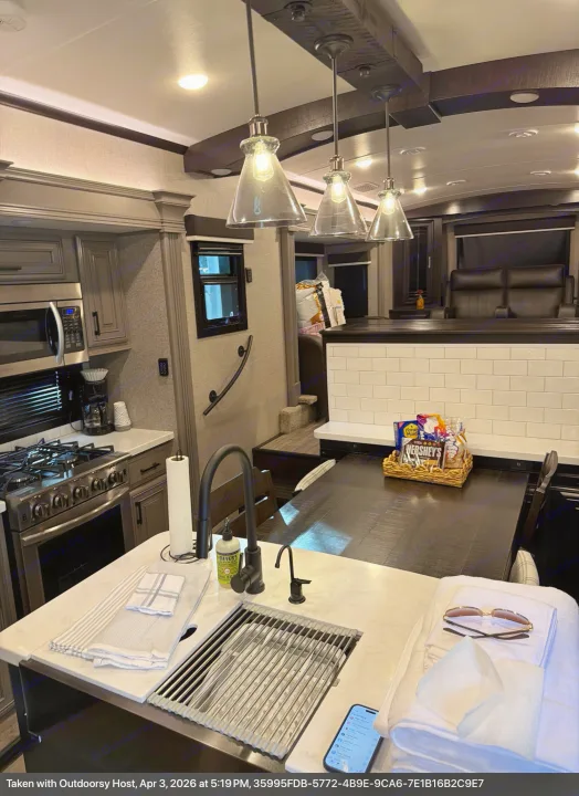 Modern and well-equipped kitchen within this luxurious rv rental, featuring full appliances and dining space.. Jayco Pinnacle 2023