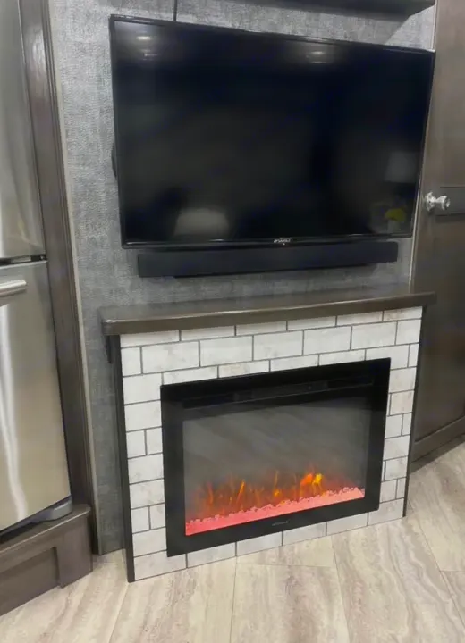 Cozy RV rental living area featuring a mounted TV, soundbar, and electric fireplace with a stylish tile surround.. Southwind Southwind Motorhome 2020
