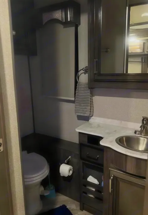 This RV rental bathroom features a compact toilet, vanity with sink, mirror, and useful storage for a functional space.. Southwind Southwind Motorhome 2020