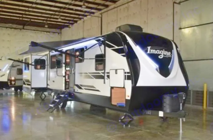 This white and black Imagine travel trailer RV rental, with an extended side and awning, is ready for adventure.. Grand Design Imagine 2021