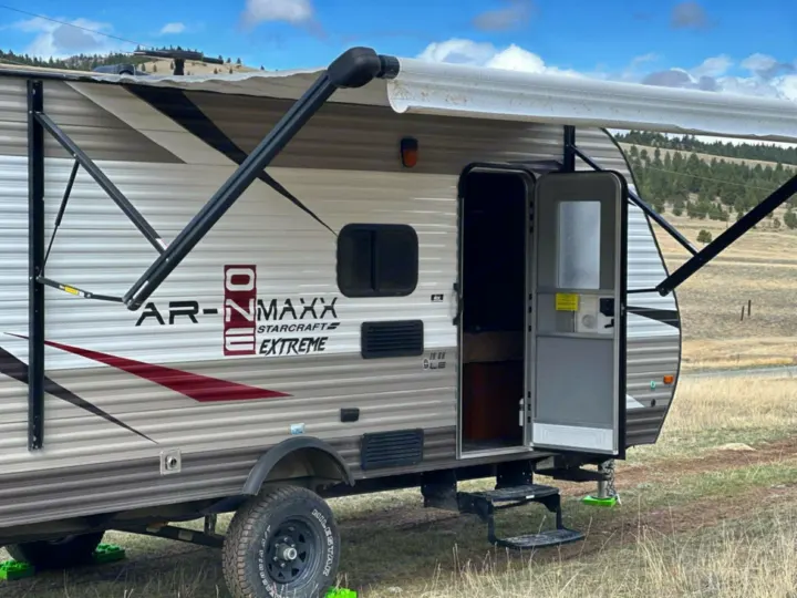 Explore the outdoors! This Starcraft Extreme travel trailer rv rental is ready for your next camping trip, parked in a scenic field.. Starcraft AR-One Maxx 2017