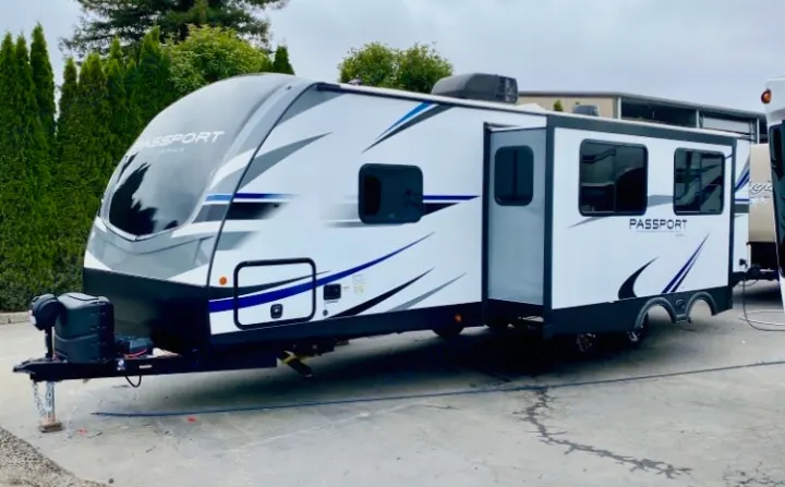 Stylish white travel trailer, a perfect RV rental for your next adventure. Features a slide-out, great for camping and travel.. Keystone RV Passport GT 2021