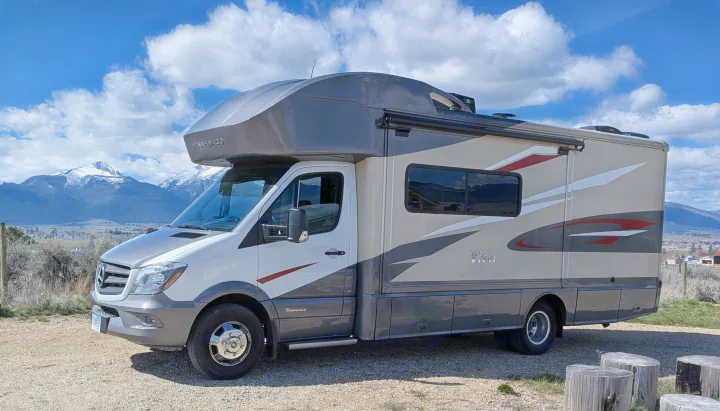 White & grey Winnebago View Class C RV rental, built on a Mercedes-Benz Sprinter, parked with scenic snow-capped mountains.. Winnebago View 2017