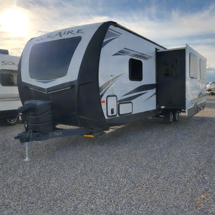 This Solaire travel trailer RV rental, with an open slide-out, is ready on a gravel lot for your next adventure.. Palomino Other 2022