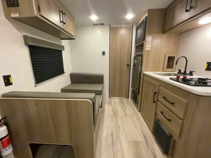 Modern compact **rv rental** interior featuring a kitchen, dinette, and ample storage for a comfortable journey.. Keystone RV Coleman 2025