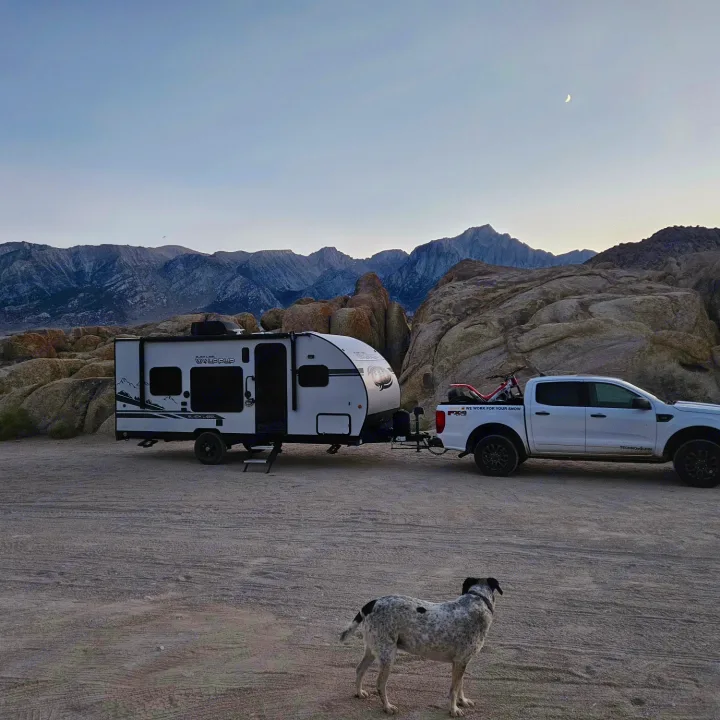 An rv rental, truck with dirt bike, & spotted dog are set against mountains at dusk. Perfect for your outdoor adventure!. Forest River Cherokee Wolf Pup 2020
