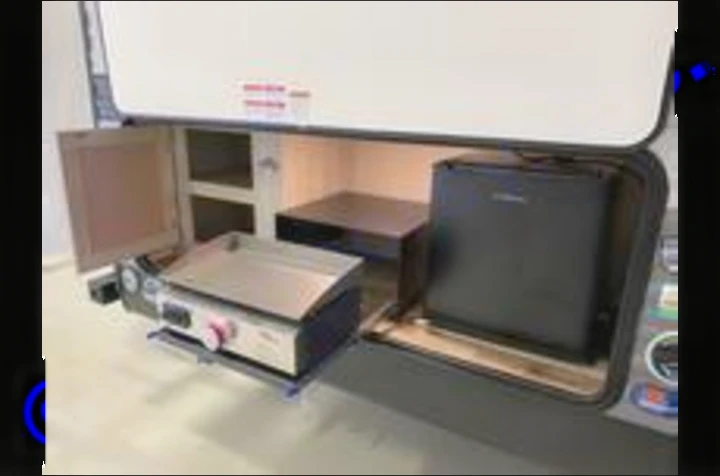 This rv rental features a well-equipped outdoor kitchen with a griddle, mini-fridge, and storage shelves.. Coachmen catalina 2022