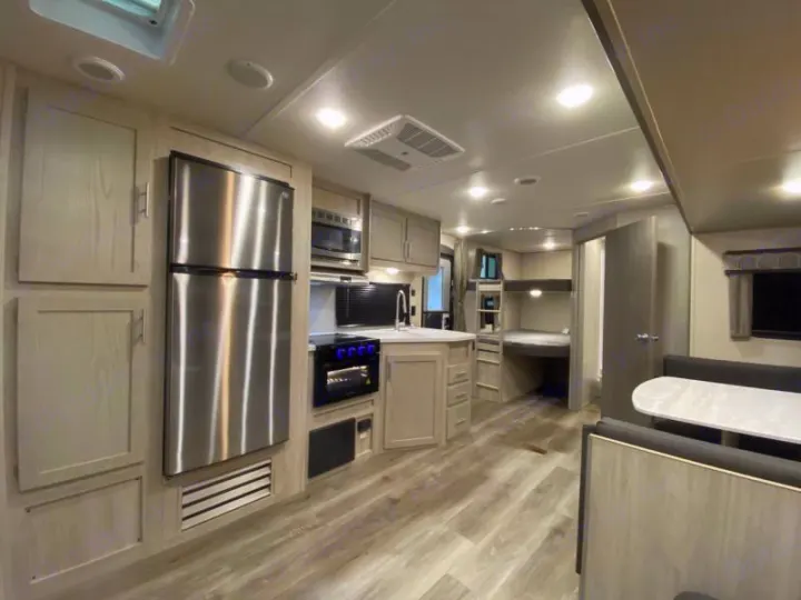Spacious RV rental interior with modern kitchen, dining area, and bunk beds. Perfect for family adventures.. Coachmen catalina 2022