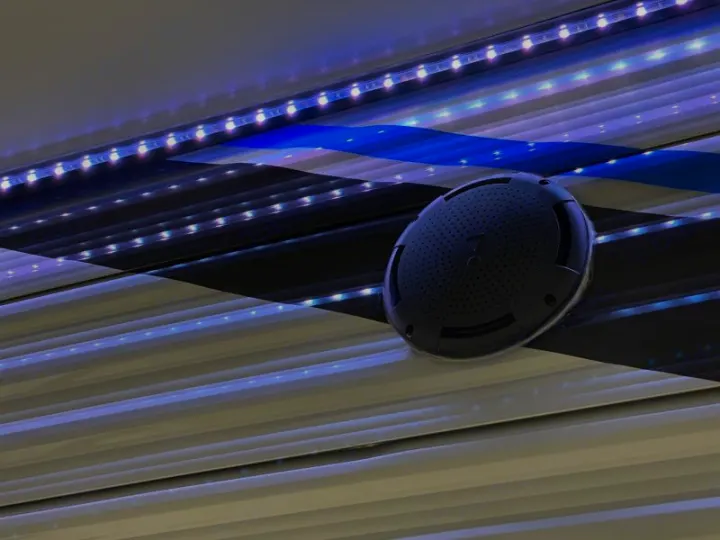 RV rental with outdoor speaker & blue LED lights illuminating a striped RV awning.. Coachmen catalina 2022