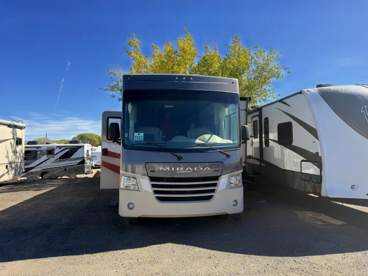 Front view of a gray Coachmen Mirada RV rental, parked in a lot with other RVs under a clear sky, ready for your next adventure.. Coachmen Mirada 32SS 2019