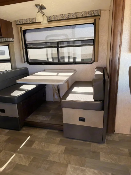 This RV rental dinette offers comfortable two-tone benches, a light table, and windows for dining and relaxing.. Coachmen Mirada 32SS 2019