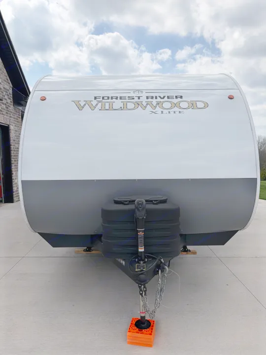Front view of a white & gray Forest River Wildwood X-Lite travel trailer, ideal for an RV rental adventure.. Forest River Wildwood X-Lite 273QBXL 2026