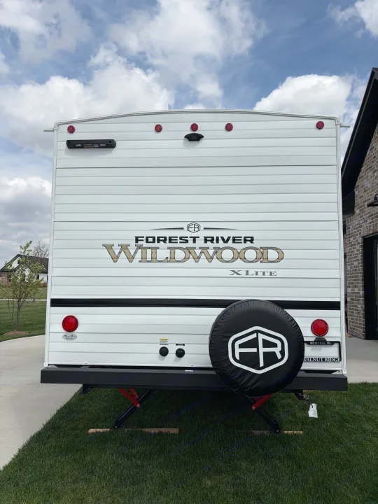 Forest River Wildwood X-Lite RV rental, showing the rear with camera, taillights, and spare tire. Ready for your next adventure!. Forest River Wildwood X-Lite 273QBXL 2026