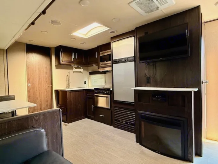 Modern RV rental interior showcasing a full kitchen, living area with TV & fireplace, and dinette for comfortable travel.. Kodiak Ultimate 288BHSL 2018