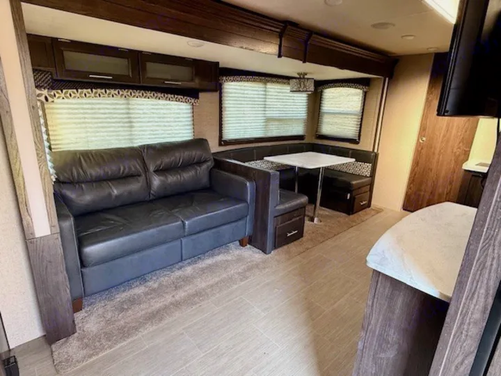 RV rental living space: dark sofa, U-shaped dinette, and overhead cabinets offer comfort for travelers.. Kodiak Ultimate 288BHSL 2018