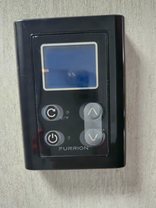 Black Furrion RV rental thermostat with digital display, power, mode, and temperature control buttons for climate.. Forest River Cherokee Wolf Pup 2024