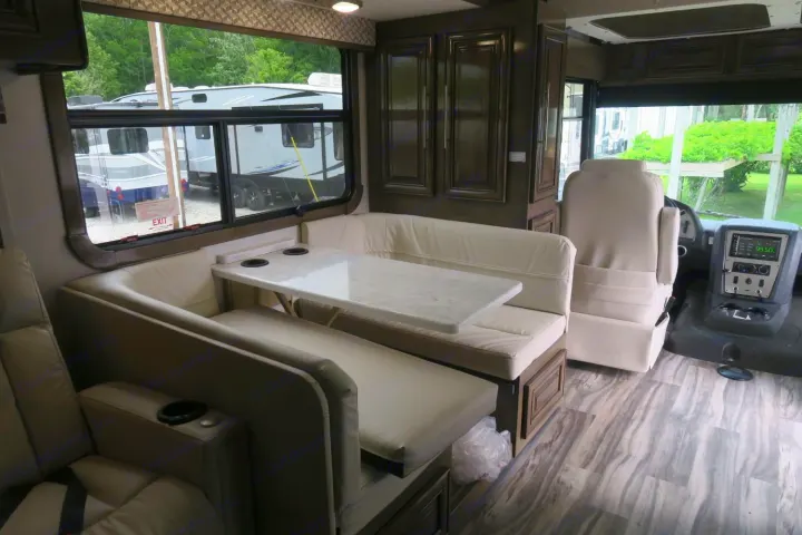 Spacious RV rental interior featuring a comfortable dinette, driver's cockpit, and large windows.. Forest River Georgetown 2020