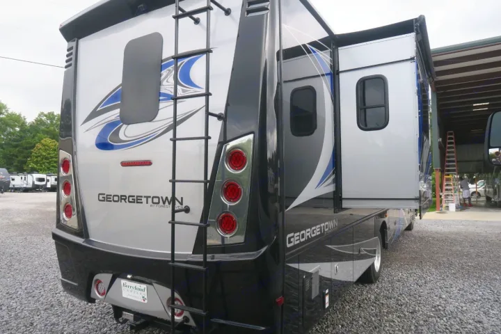 Georgetown RV rental. Rear view showing silver/black motorhome with ladder, red taillights, and extended side slide-out.. Forest River Georgetown 2020