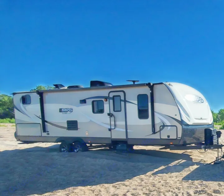 An MPG Ultra Lite travel trailer RV rental, stuck in deep sand under a clear blue sky. Ready for an outdoor adventure!. Cruiser RV MPG Ultra Lite 2017