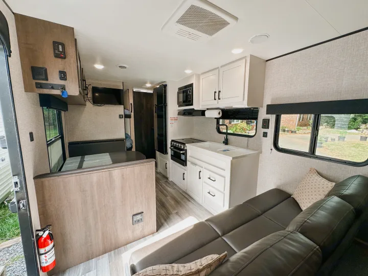 Modern rv rental interior: well-equipped kitchen, cozy dinette, comfortable couch, and bunks. Bright and ready for adventure.. Jayco Jay Flight SLX 2024