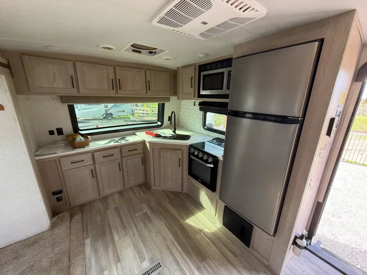 Spacious RV rental kitchen featuring light wood cabinets, stainless steel appliances, and hexagon backsplash, ready for adventures.. Forest River Flagstaff Super Lite 2021