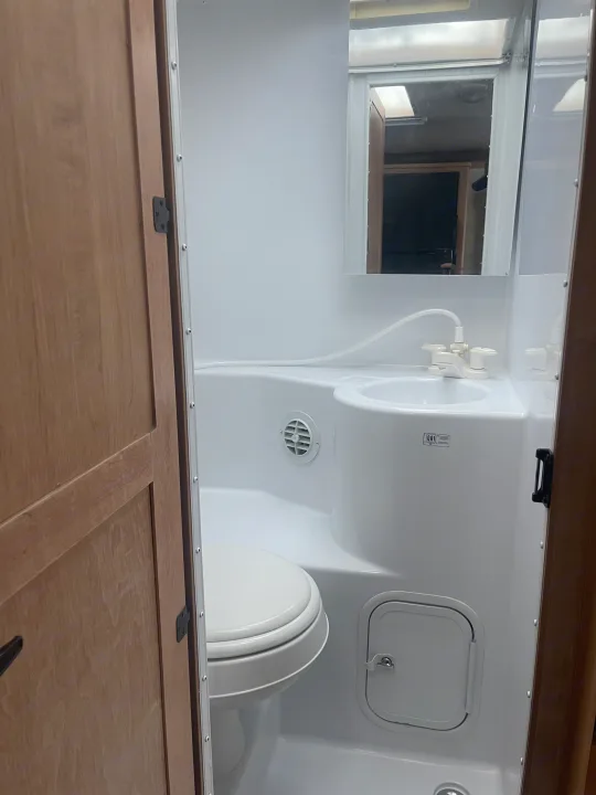 Compact RV rental wet bath, featuring an integrated sink with shower faucet, toilet, and storage hatch.. Adventurer Lp Adventurer 2016