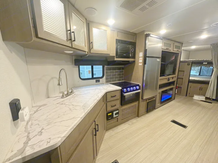 Spacious rv rental interior featuring a modern kitchen with marble counters, bunk beds, and a cozy living area.. Keystone RV Hideout Luxury 2021