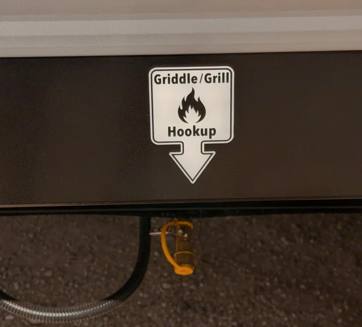 RV rental: Griddle/grill hookup with gas quick-connect and hose, ready for outdoor cooking.. Keystone Coleman 2026