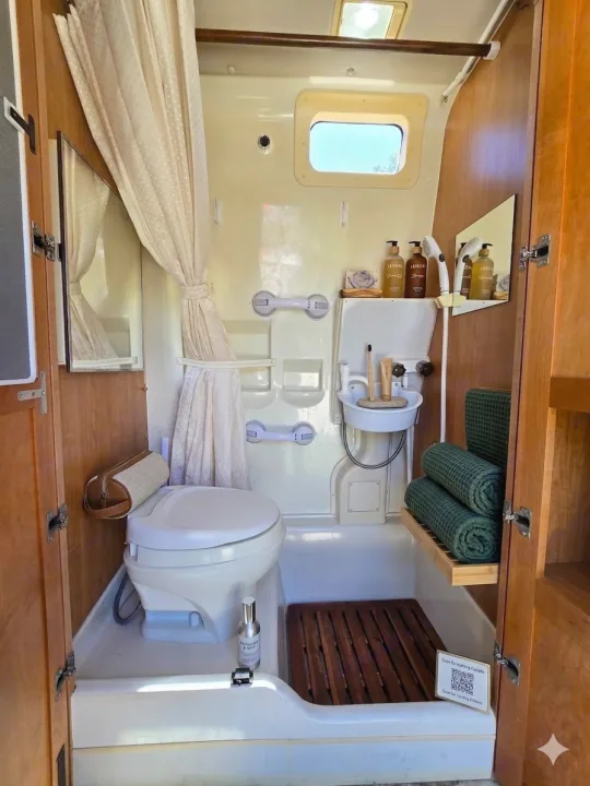 RV rental bathroom: compact and well-equipped with a toilet, shower, sink, and toiletries for a comfortable journey.. Leisure Travel Vans Leisure Travel Vans Class B 2005