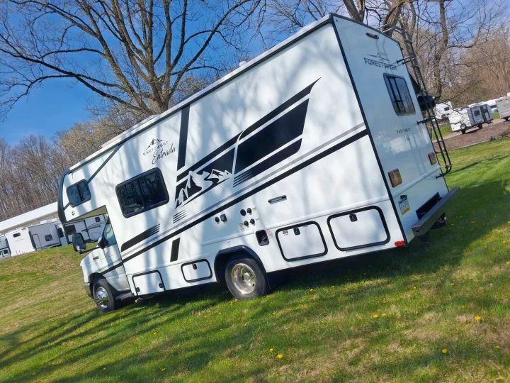 This white East to West Entrada RV rental is ready for adventure, parked in a sunny, grassy field. Perfect for your next trip!. East to West Entrada 2026