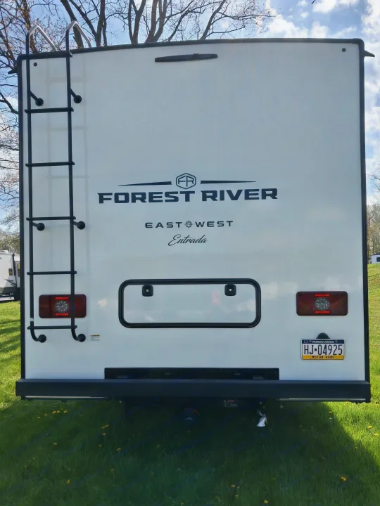 Back of a white Forest River East West Entrada RV rental, featuring a ladder, LED taillights, and a PA motor home license plate.. East to West Entrada 2027