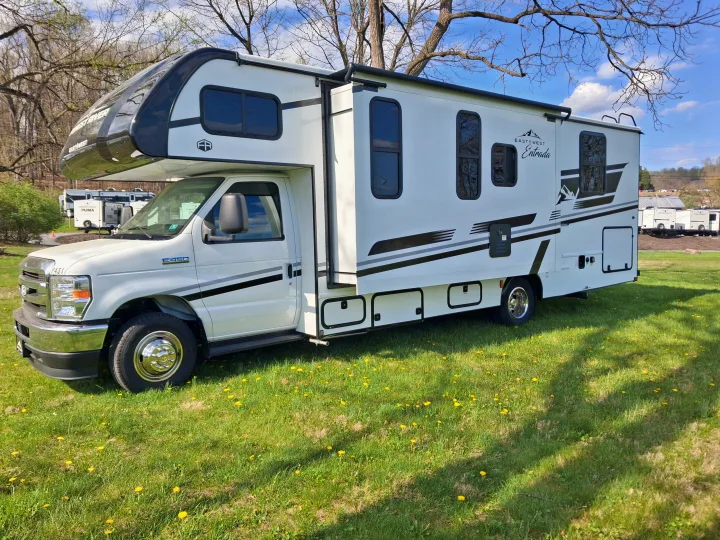 East to West Entrada Class C rv rental on green grass with trees, perfect for camping trips.. East to West Entrada 2027