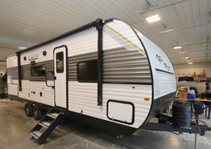 This white travel trailer RV rental, featuring grey stripes and an awning, is ready for your next road trip or camping adventure.. Highland Ridge RV Colt 2026